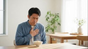 逆流性食道炎の症状を心配し、目の前の卵かけご飯を食べるべきか悩んでいる日本人男性。